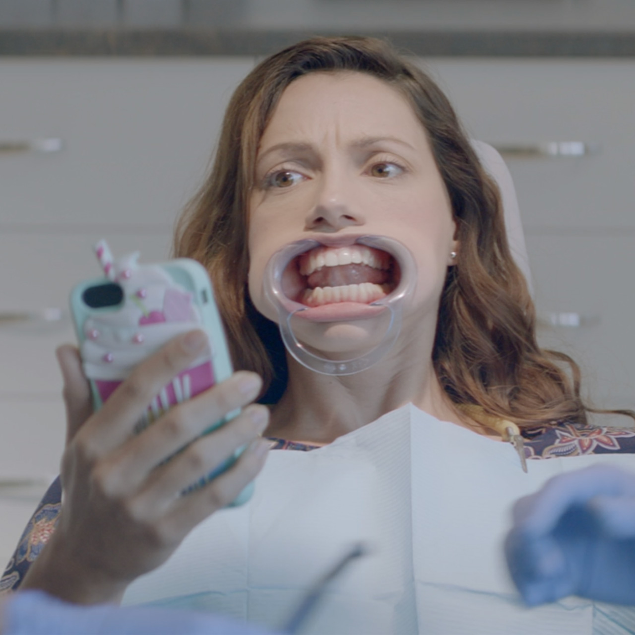 Woman at the dentist looking at her phone
