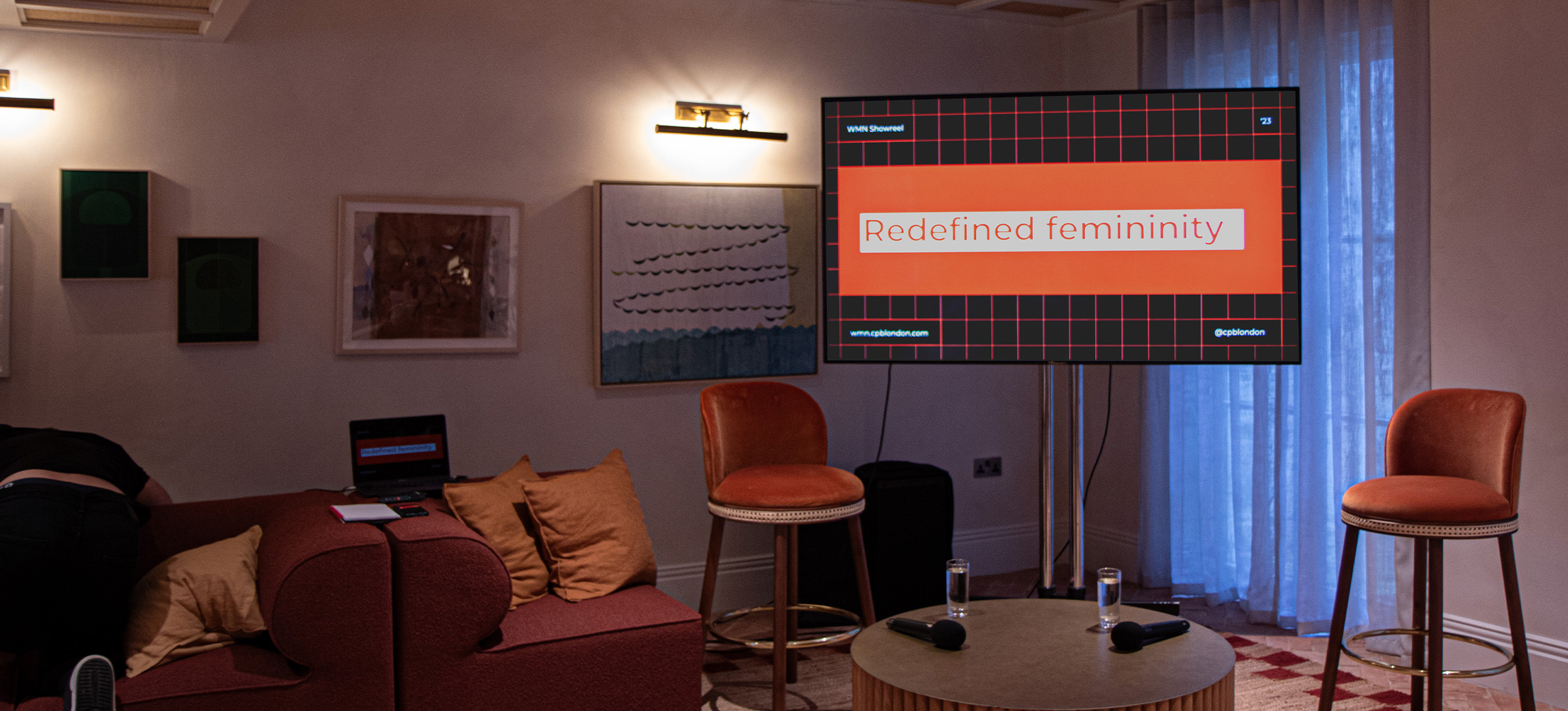 Two speaker chairs in front of a screen playing the women's reel